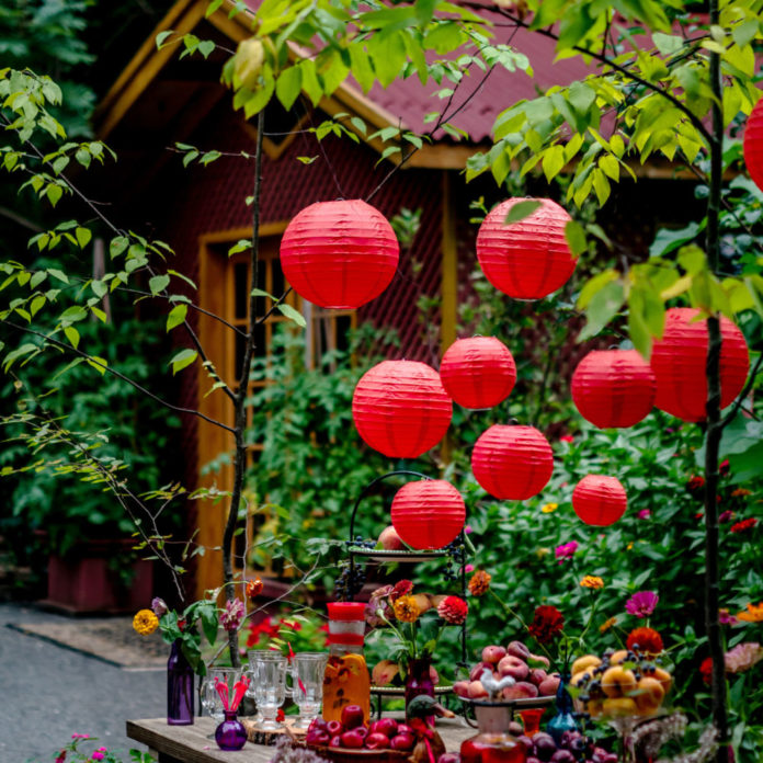 Red paper lanterns hanging above an outdoor party table