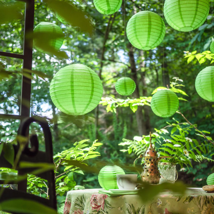 Green lanterns hanging above a table with a tea cup