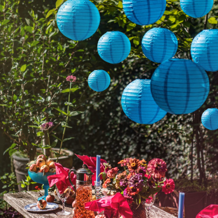 Blue paper lanterns hanging above a party table