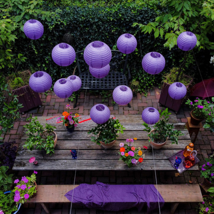 Purple paper lanterns hanging above an outdoor table