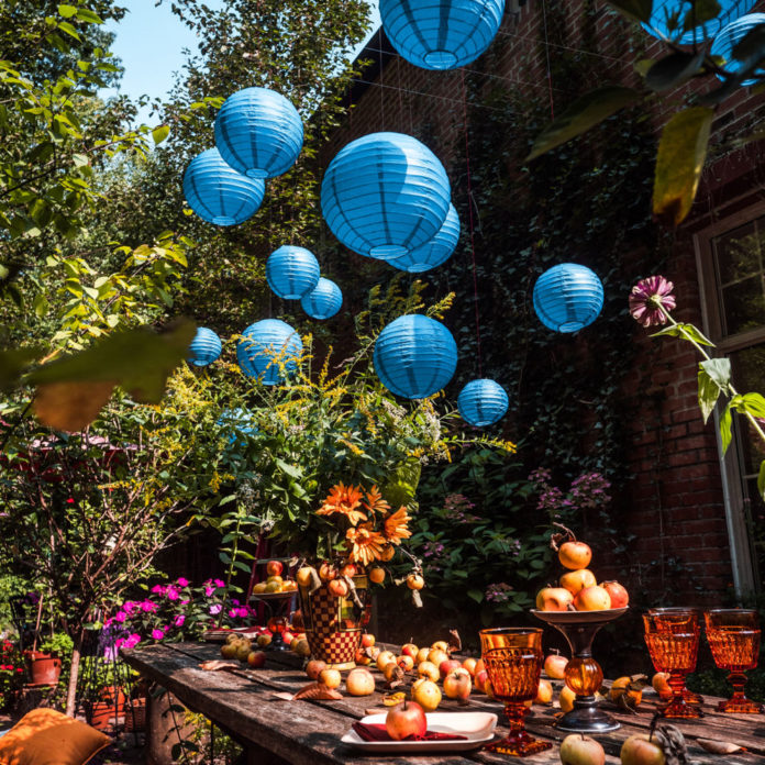 Blue paper lanterns hanging above a party table with apples