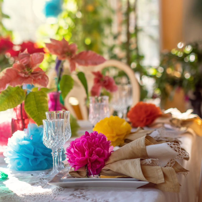 Colorful tissue paper pom poms on a party table