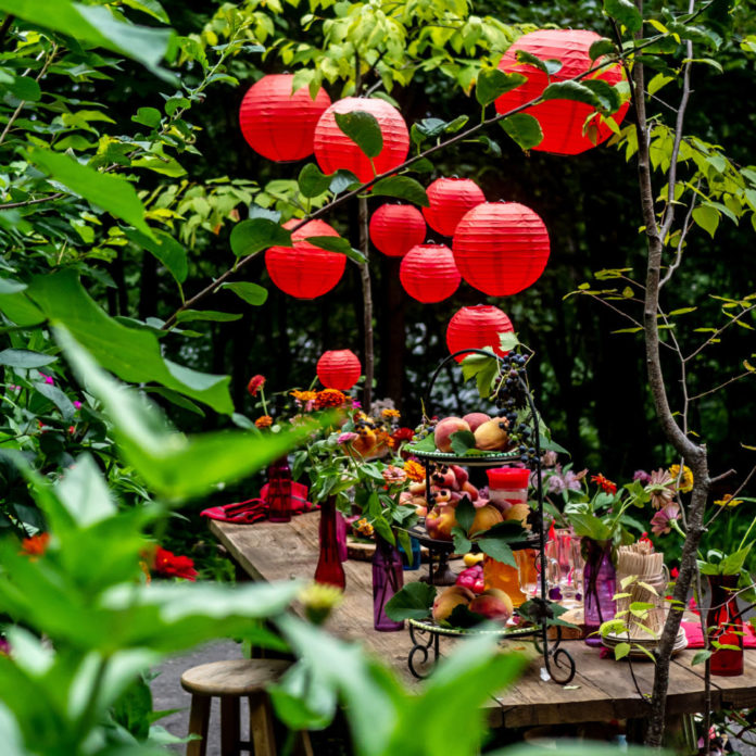 Red paper lanterns hanging above an outdoor party table